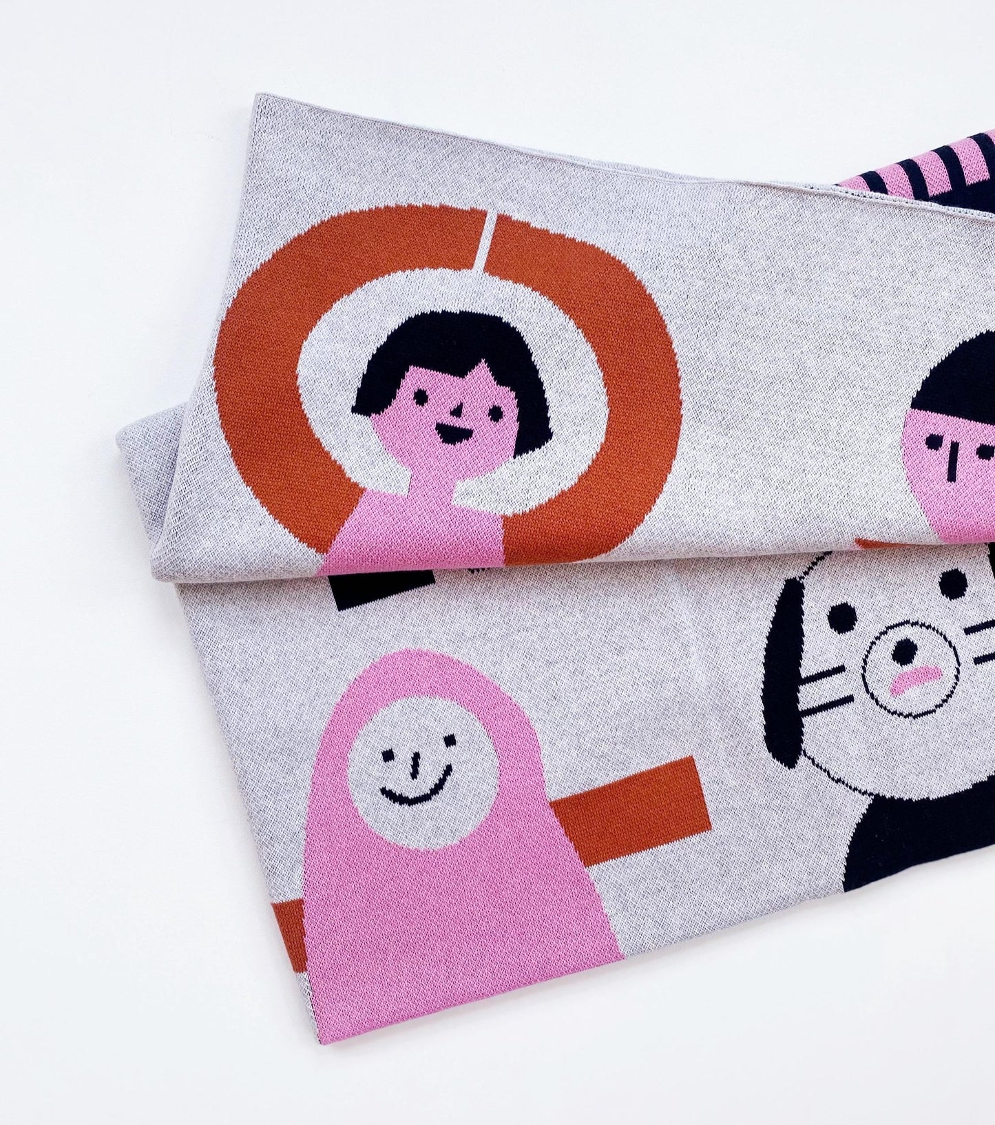 Folded knitted blanket with cartoon characters on a white background