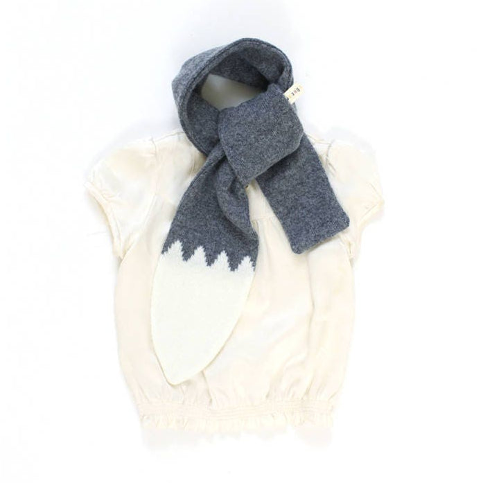 Gray knitted lambswool scarf shape like a wolf tail, draped over a white sleeveless top on a white background