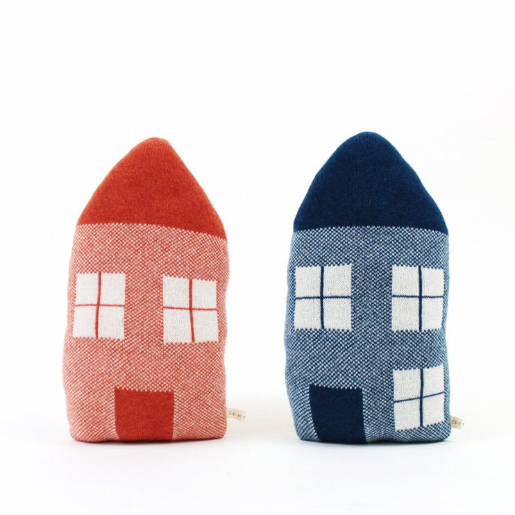 Two knitted house-shaped pillows, one red and one blue, on a white background.