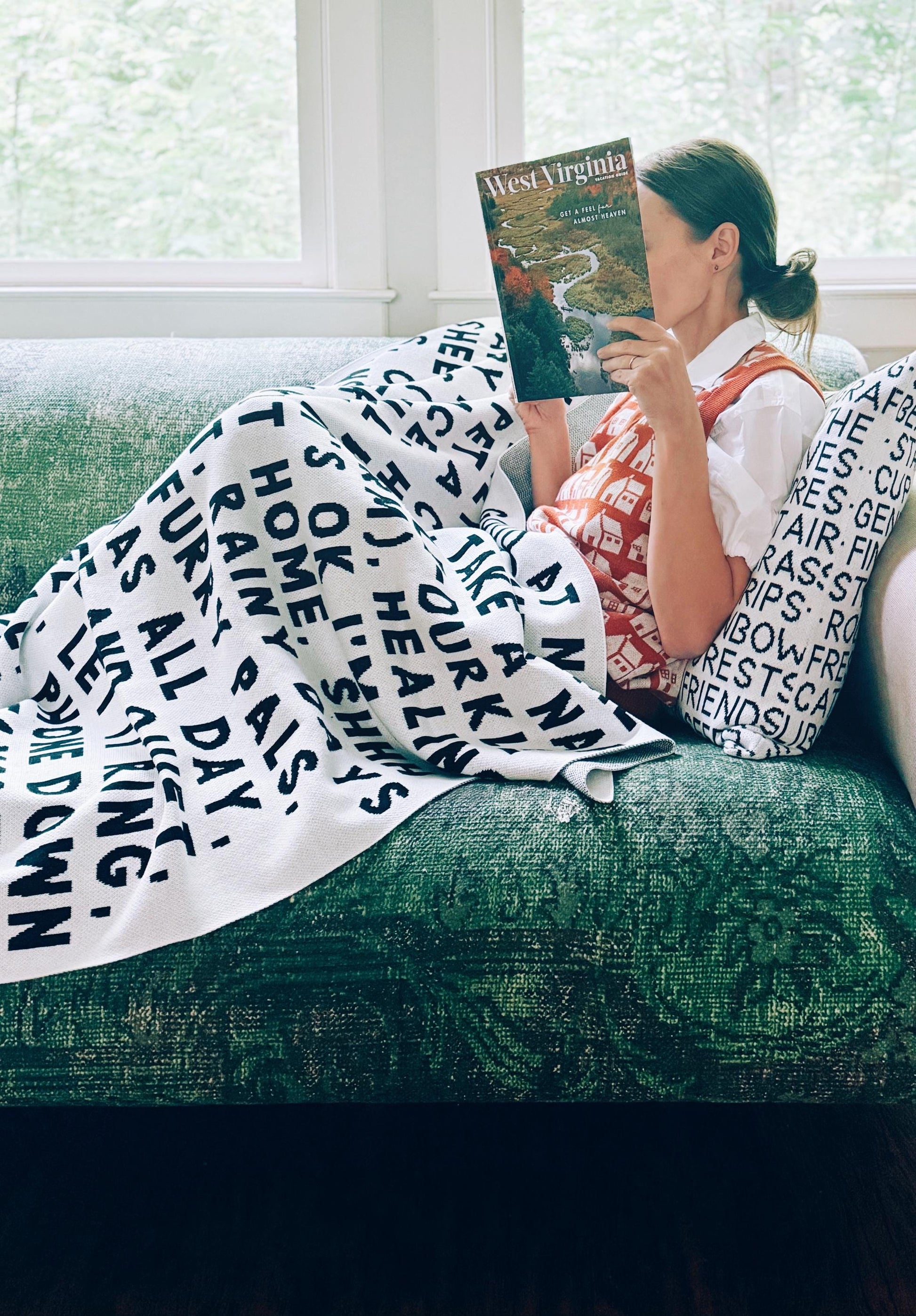 Woman sitting on a couch with a blanket and book, surrounded by nature-themed text.