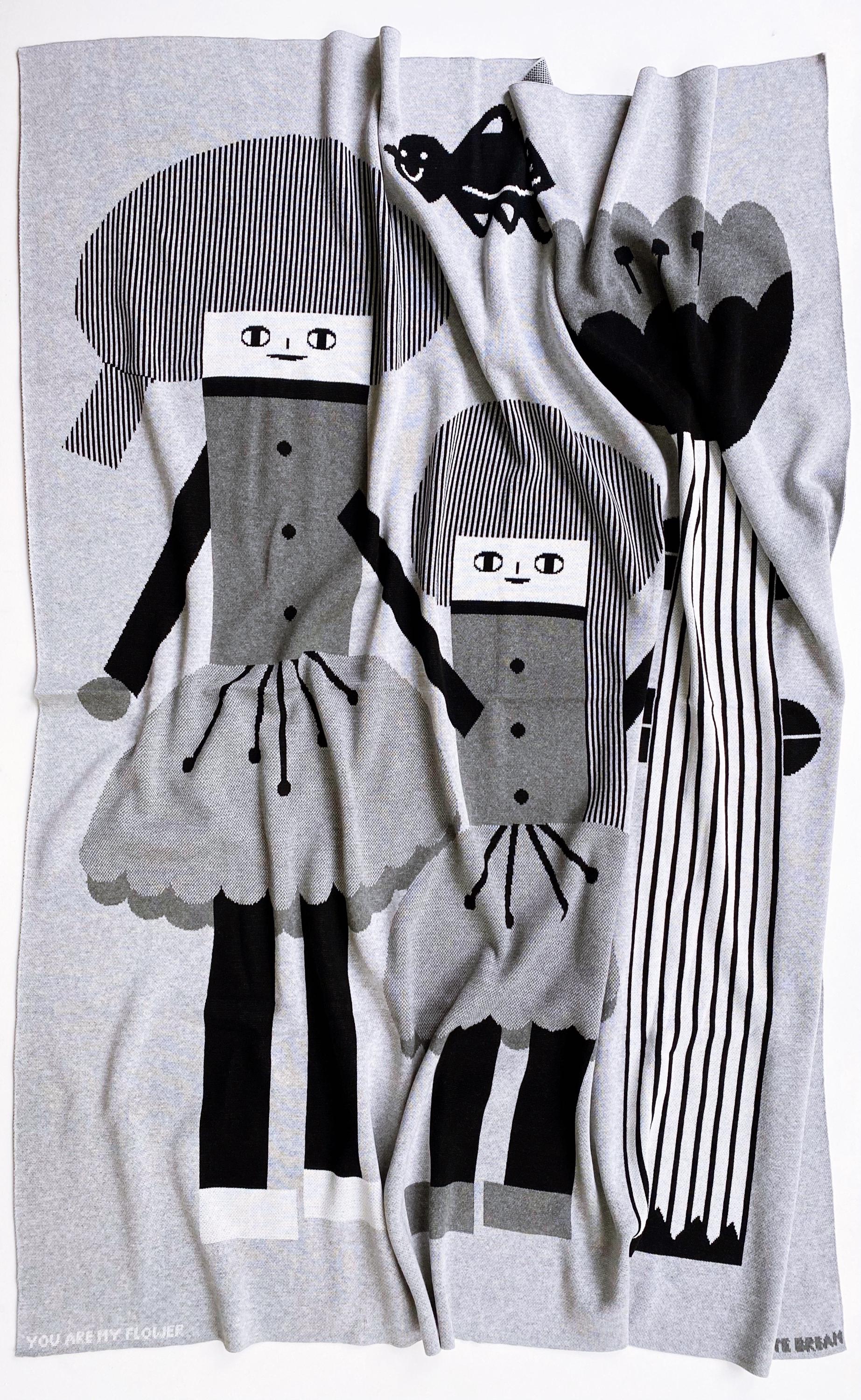 Knitted blanket with cartoon character design on a white background