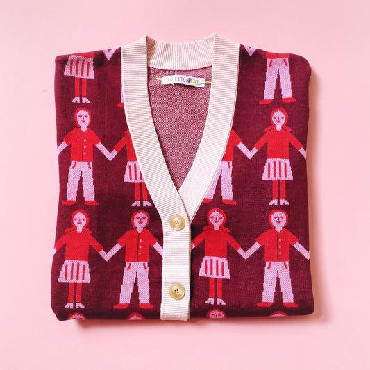 Knit sweater cardigan with a pattern of people holding hands on a pink background