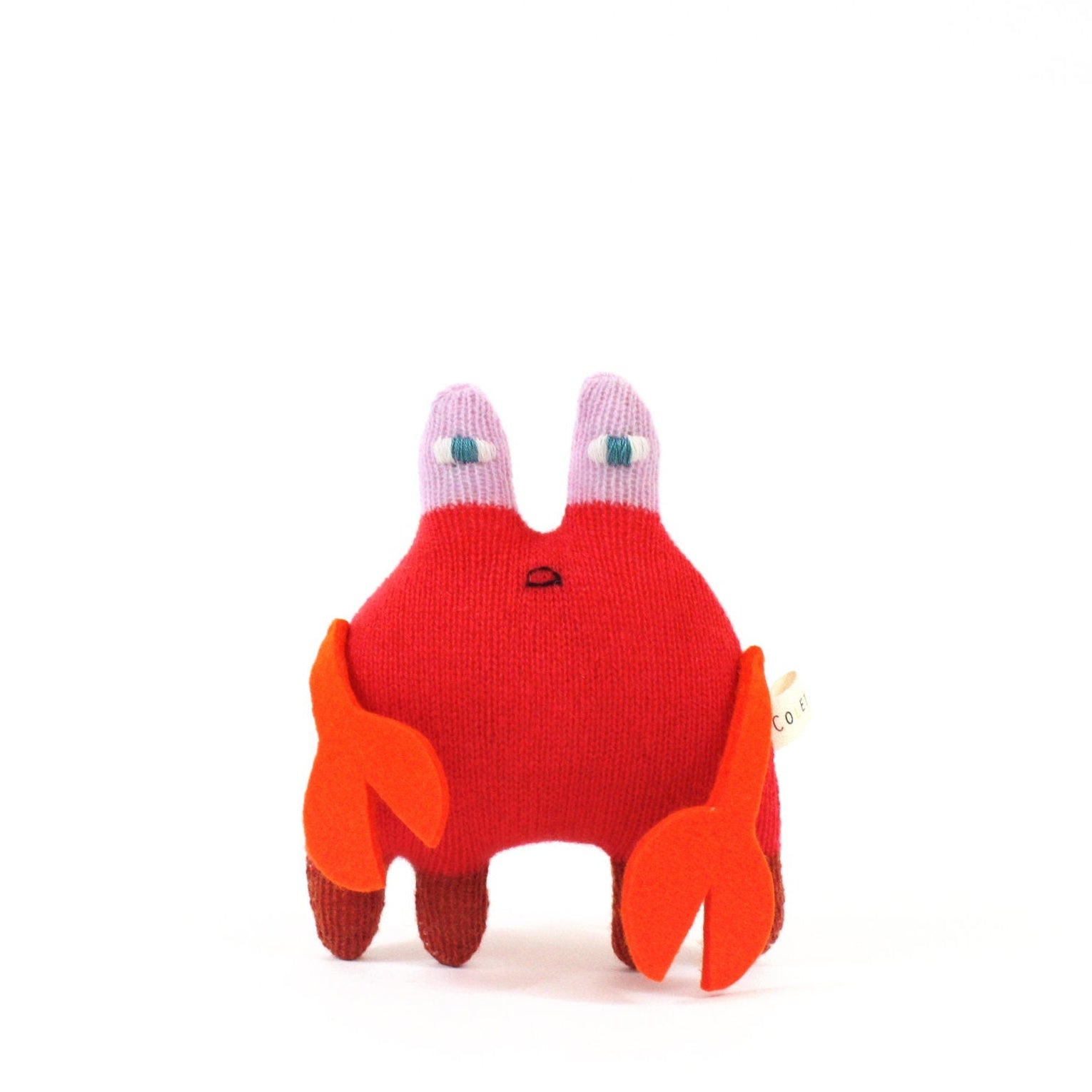Red crab-shaped knitted toy with orange claws on a white background