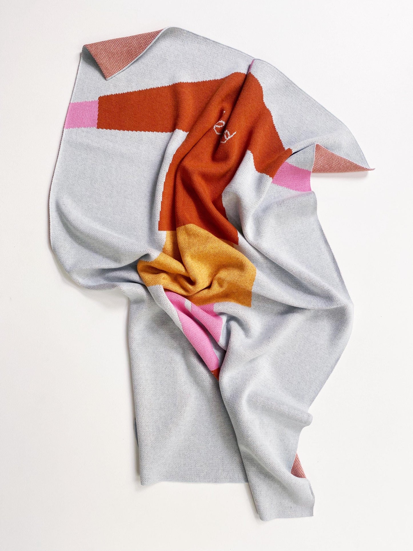 Colorful knit fabric with geometric pattern on a white background