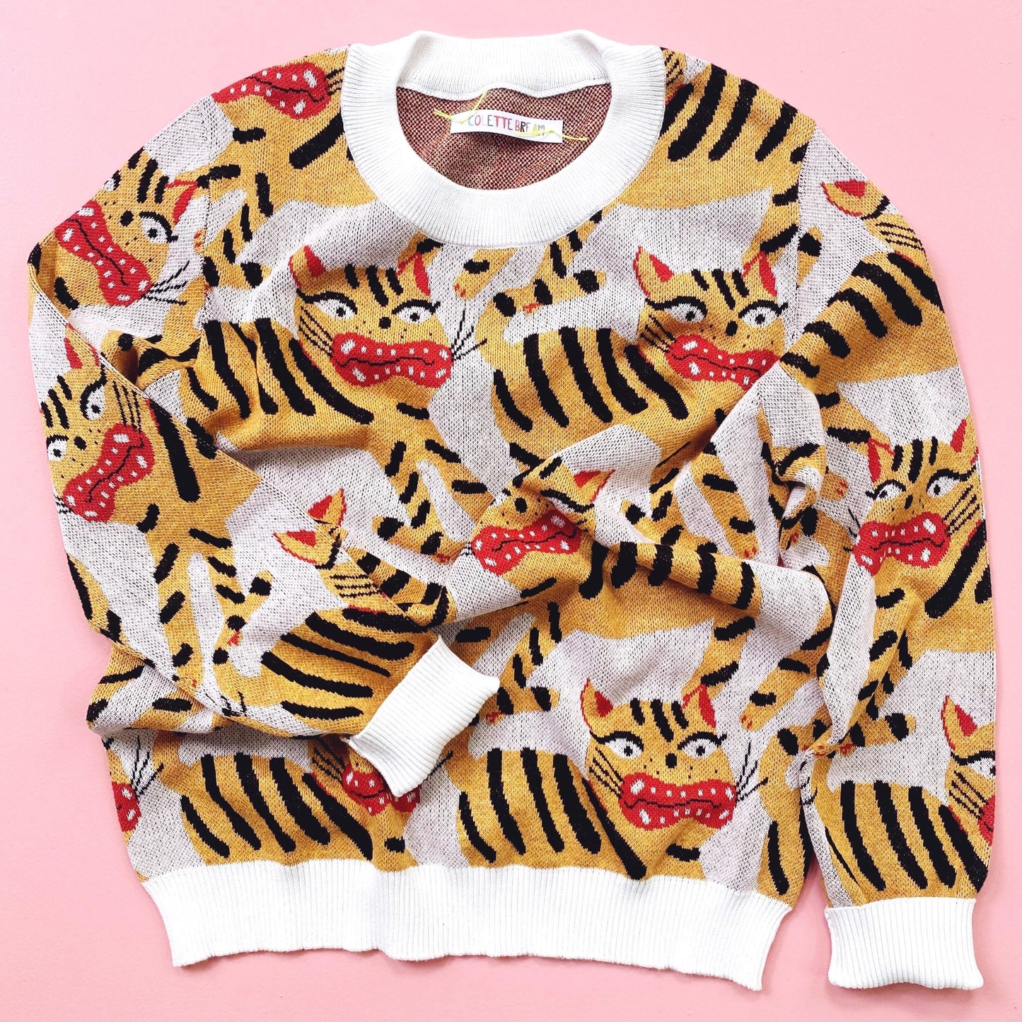 Sweater with hariko tora tiger pattern on a pink background