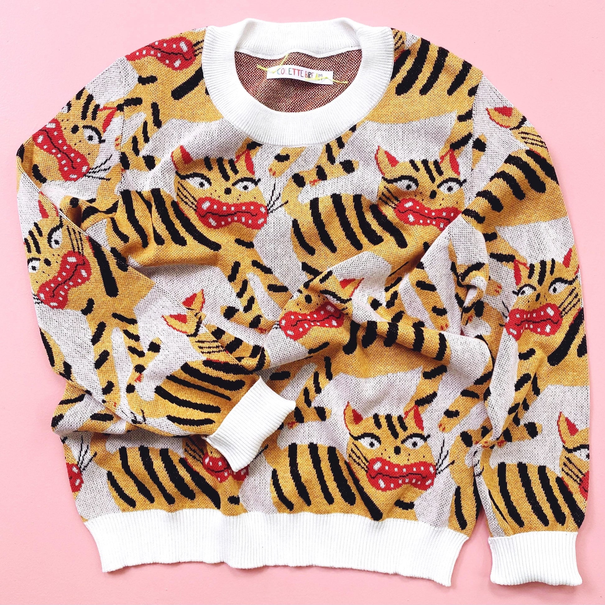 Sweater with hariko tora tiger pattern on a pink background