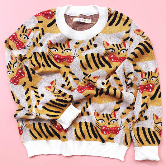 Sweater with hariko tora tiger pattern on a pink background