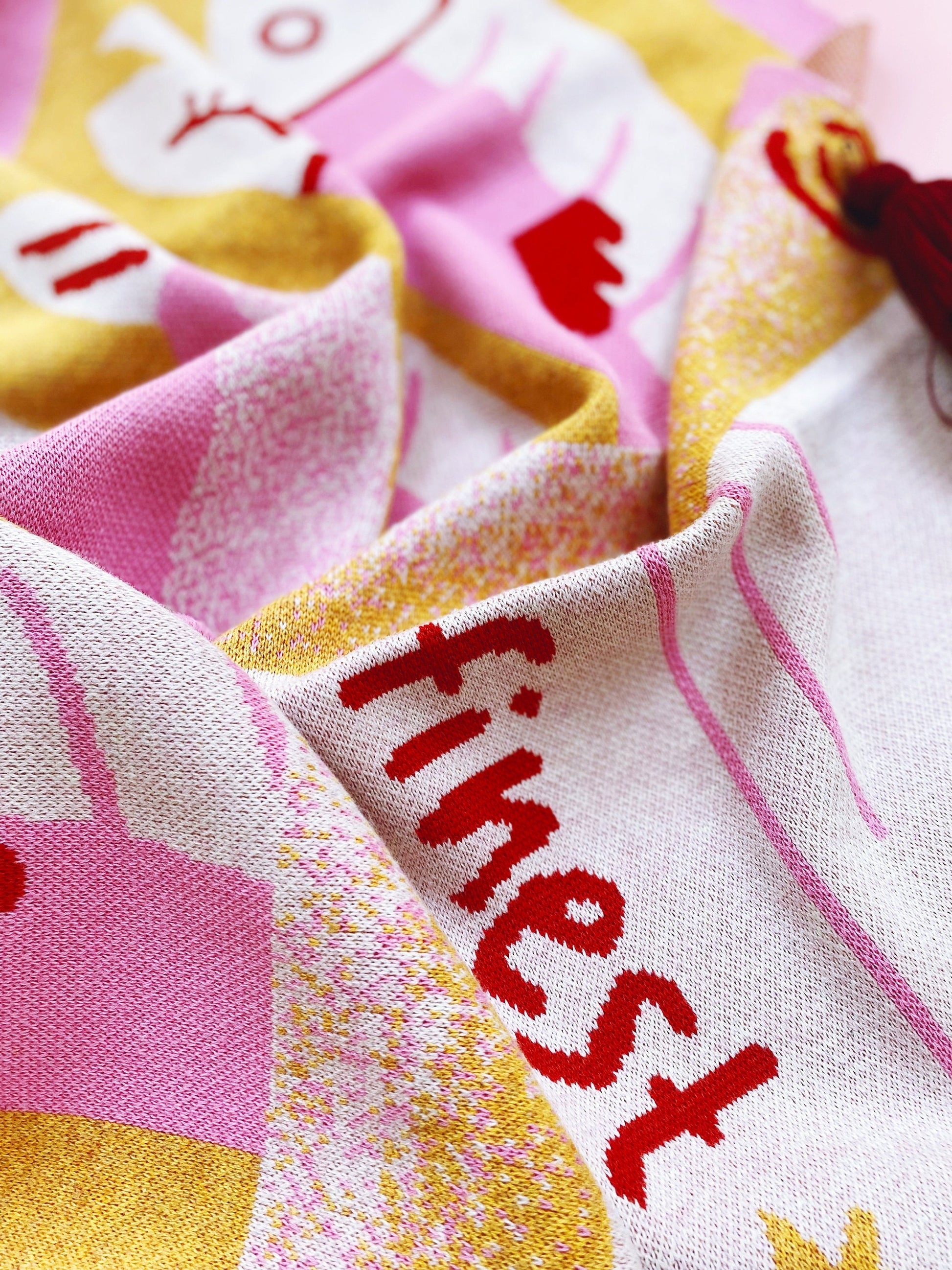 Textile with 'finest' embroidery on a colorful knit fabric background