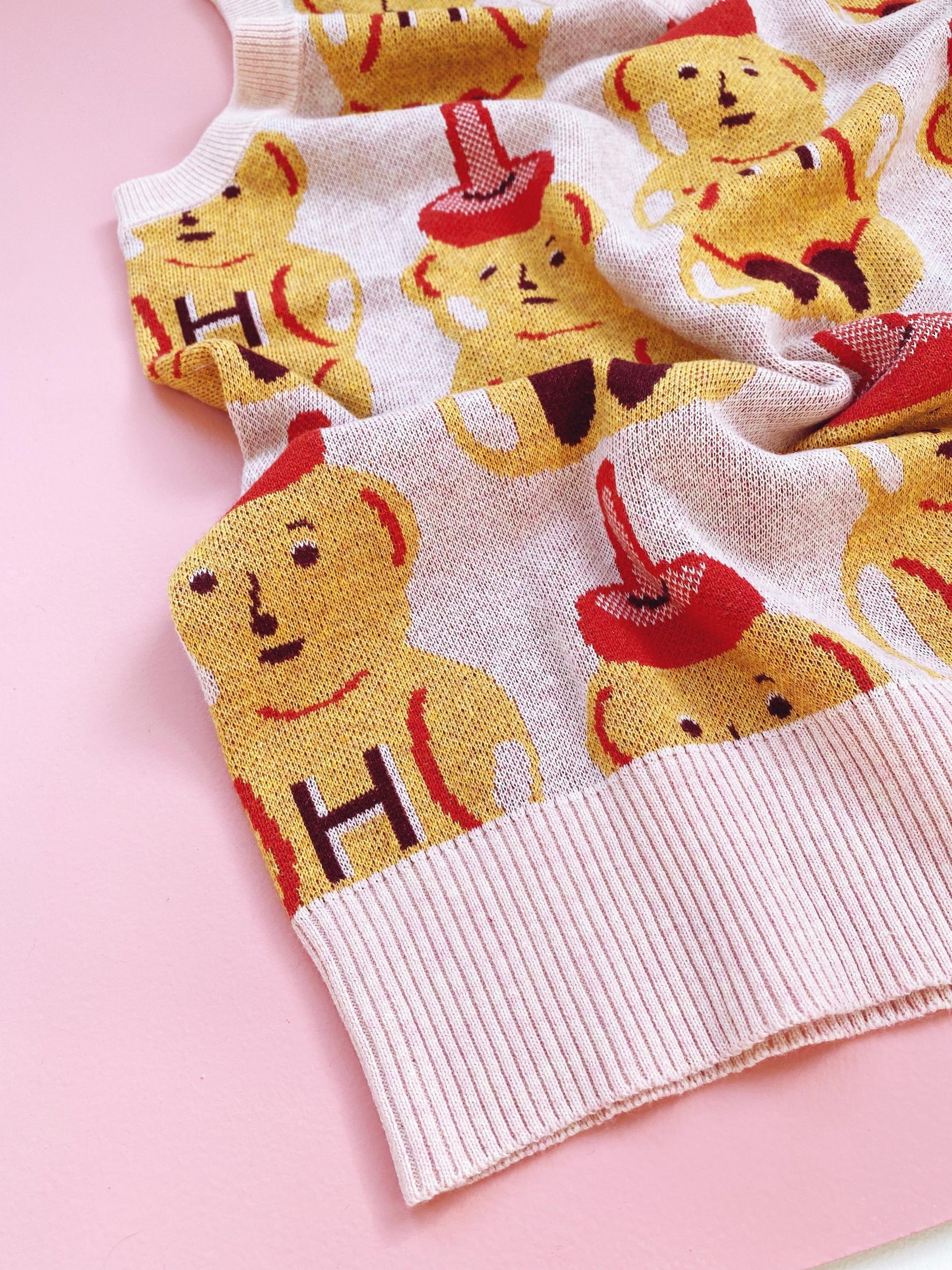 Sweater vest with honey bear pattern on a pink background
