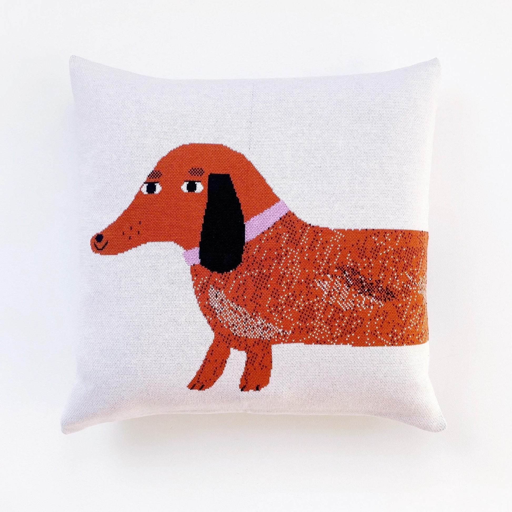 Decorative pillow with a dachshund design on a white background