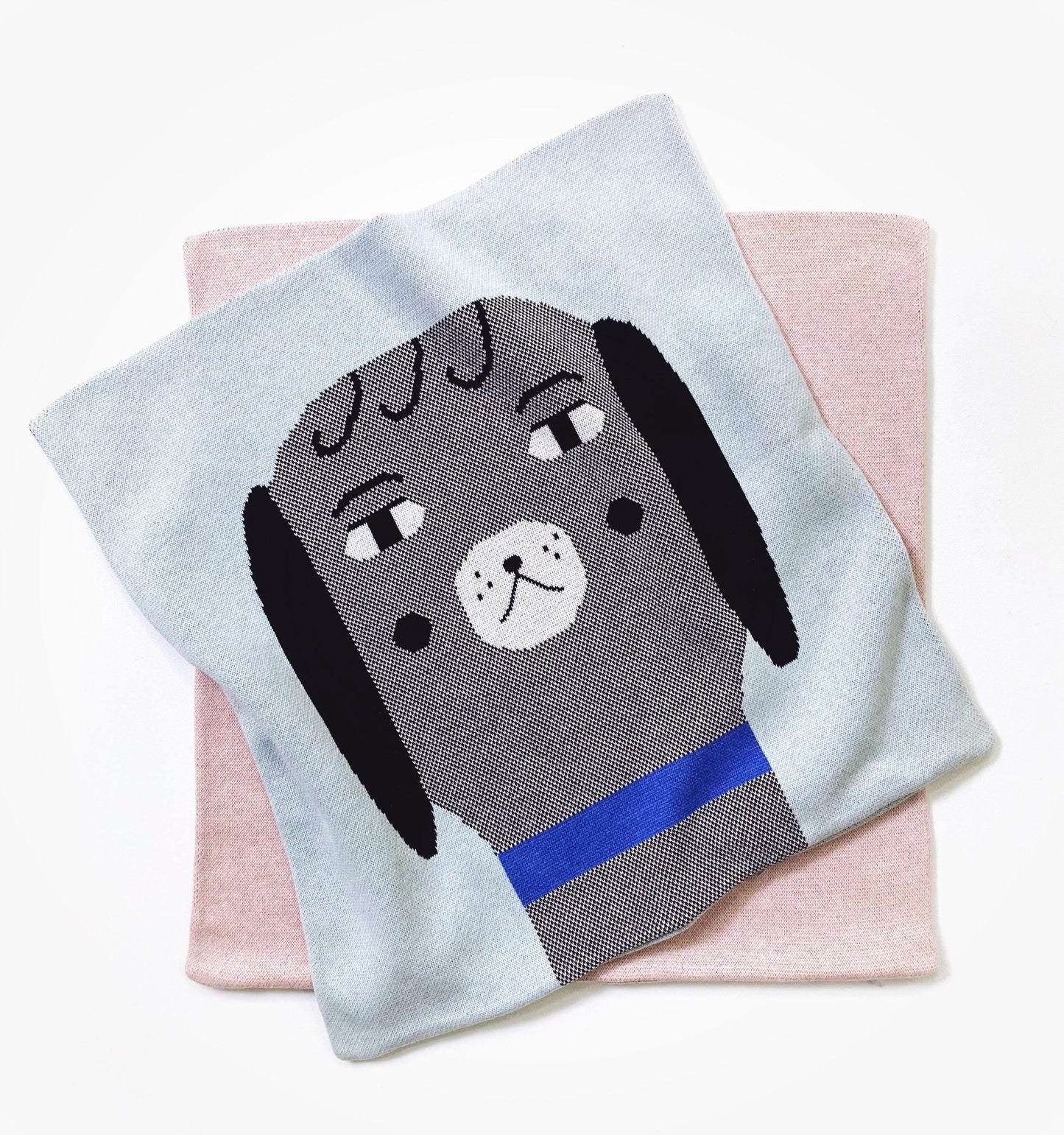 Knitted pillow with a dog design on a pink surface