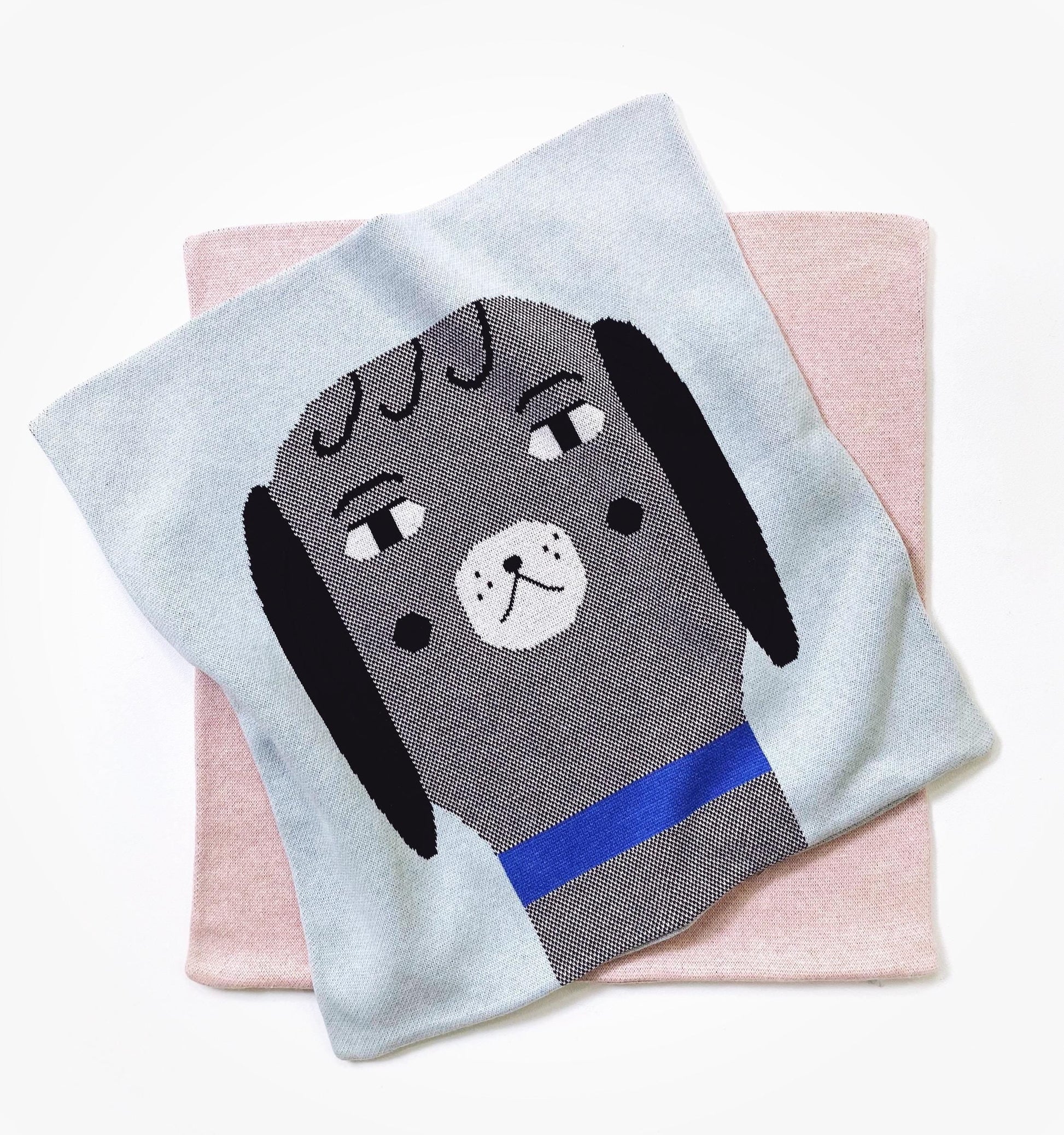 Knitted pillow with a dog design on a pink surface