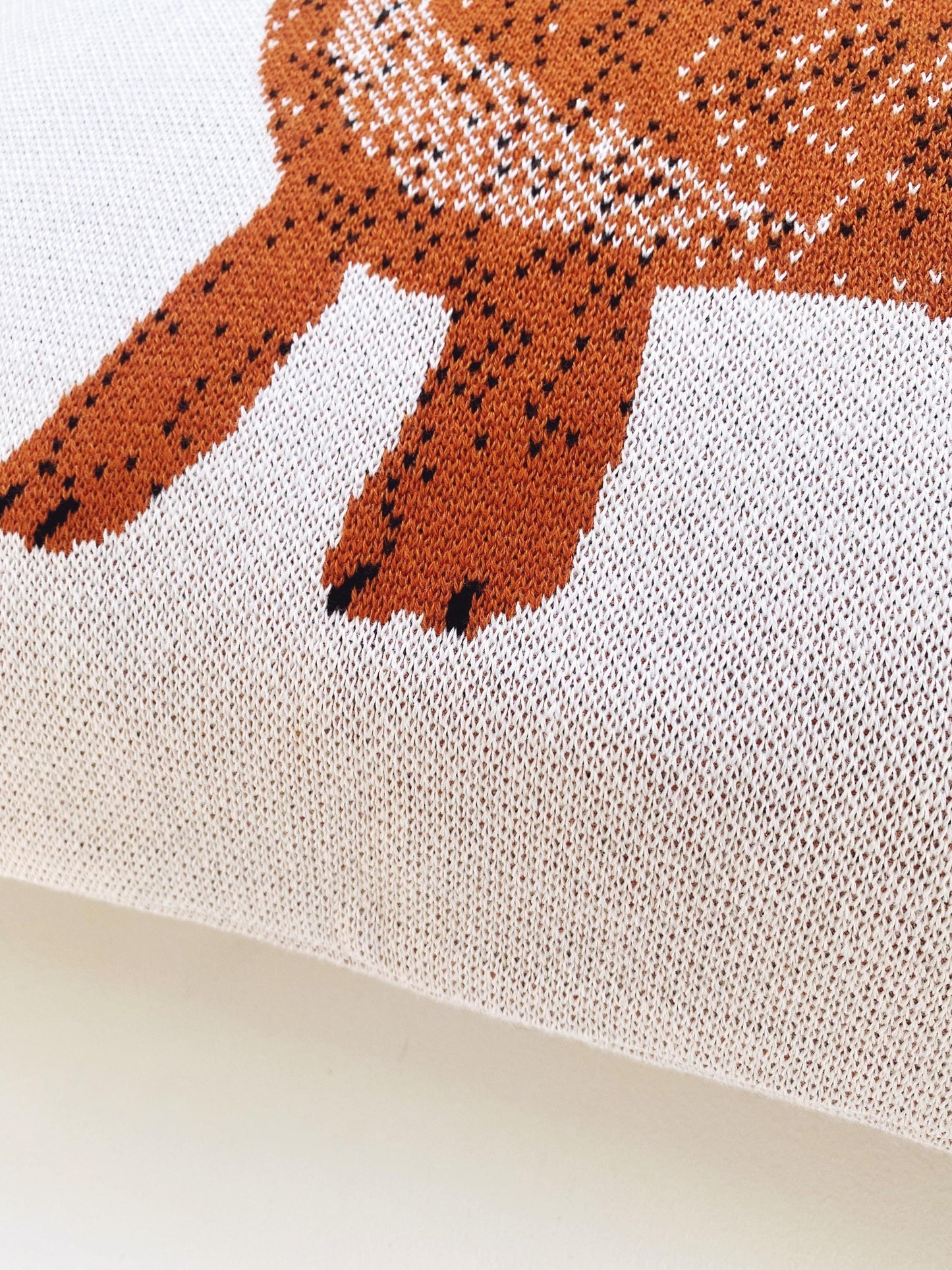 Close-up of a knitted fabric with a brown dachsund dog design on a white background