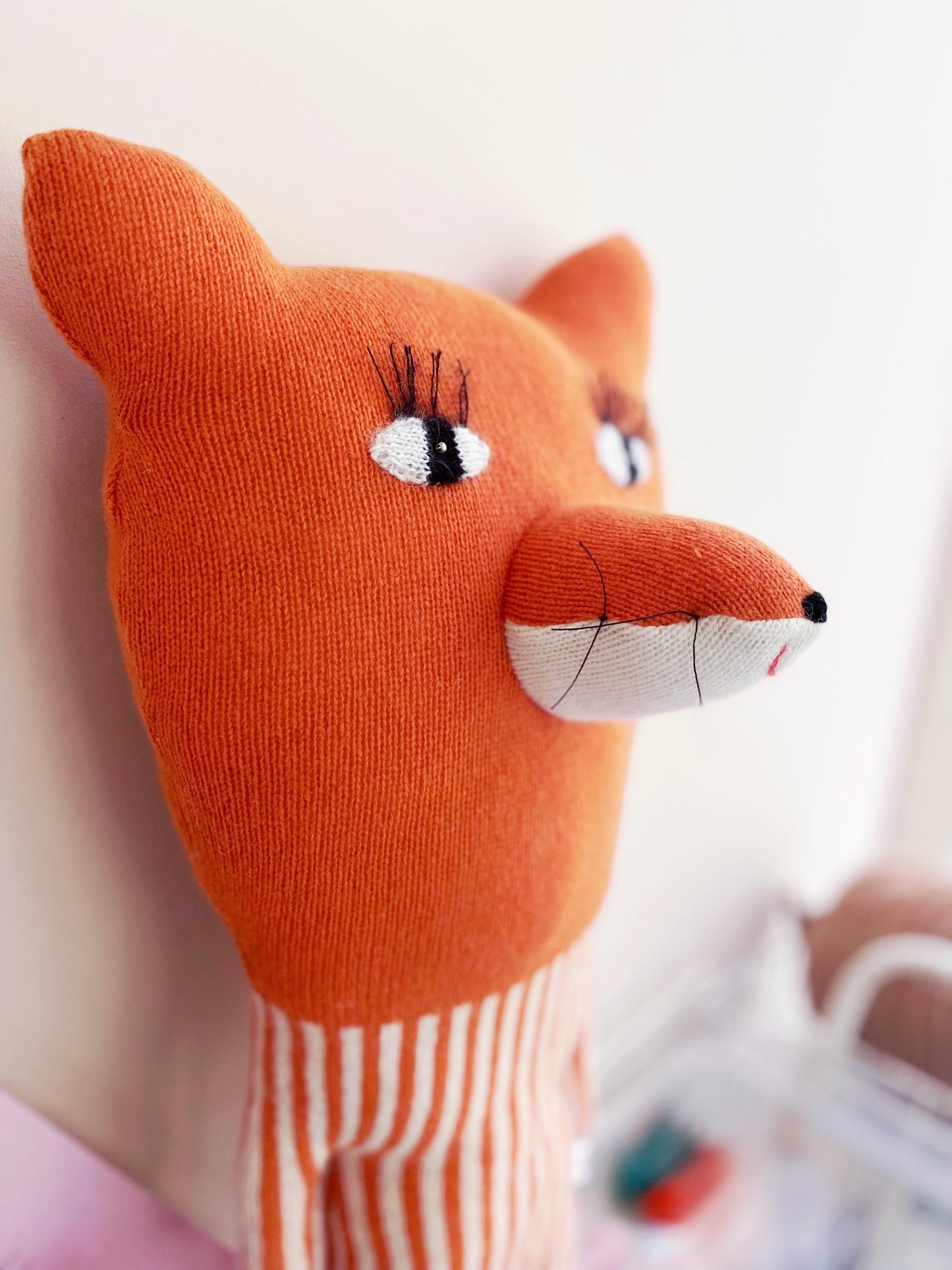 Close-up of an orange fox plush toy with a blurred background