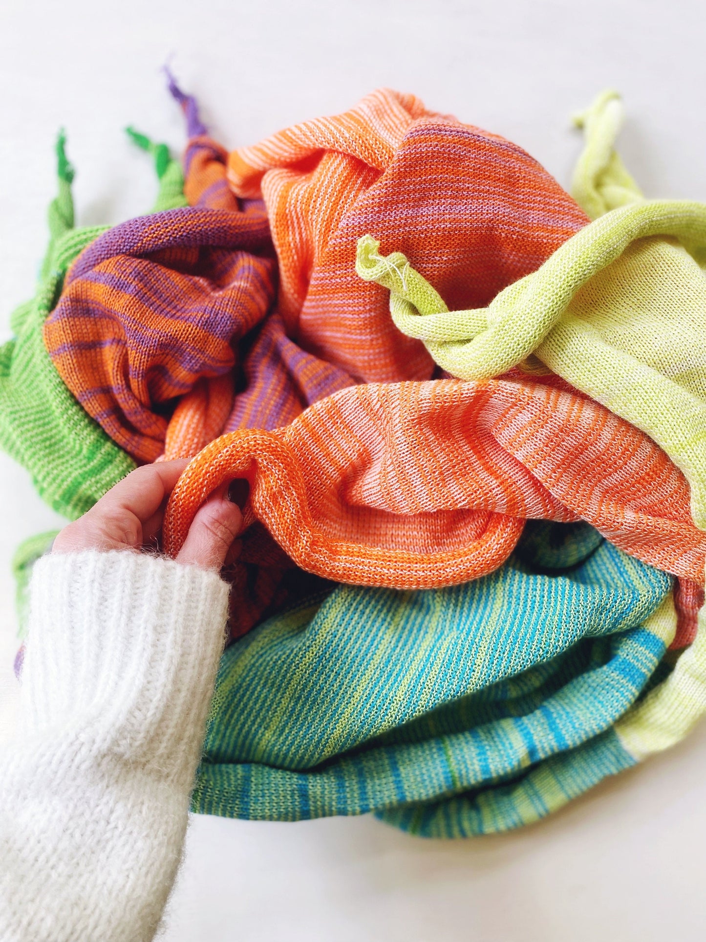 Stack of colorful folded knitted fabrics on a white background