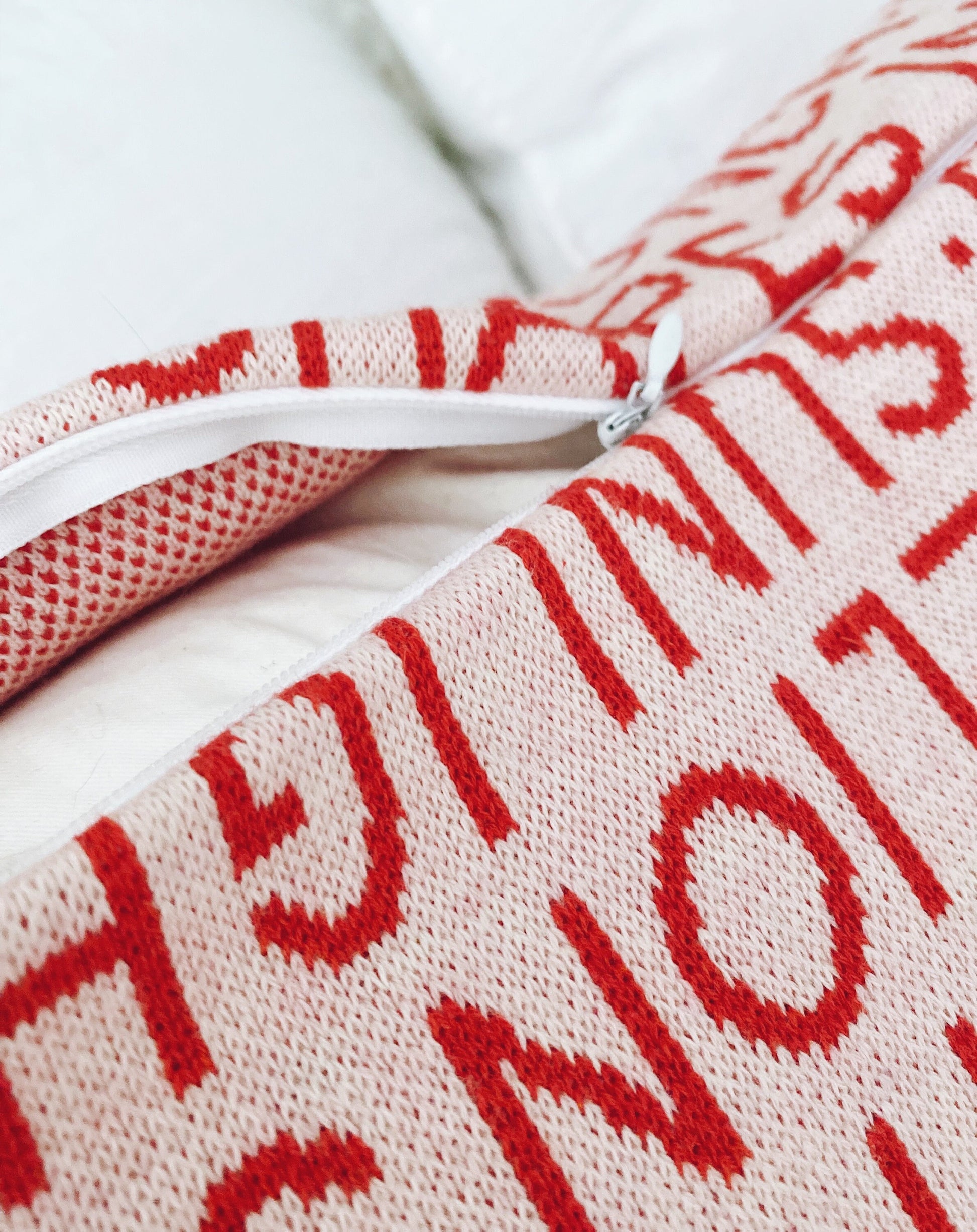 Close-up of a textured knit fabric with red text on a white background